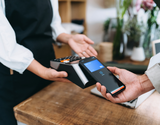 Person using a device to take a payment from a Smartphone