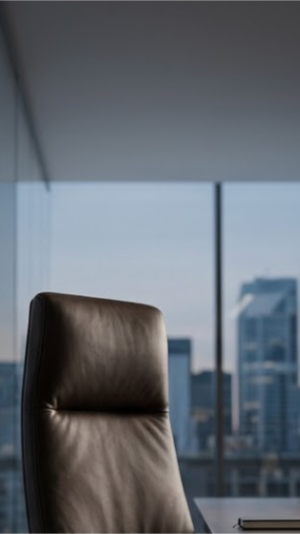 A boardroom chair with a city view outside the window